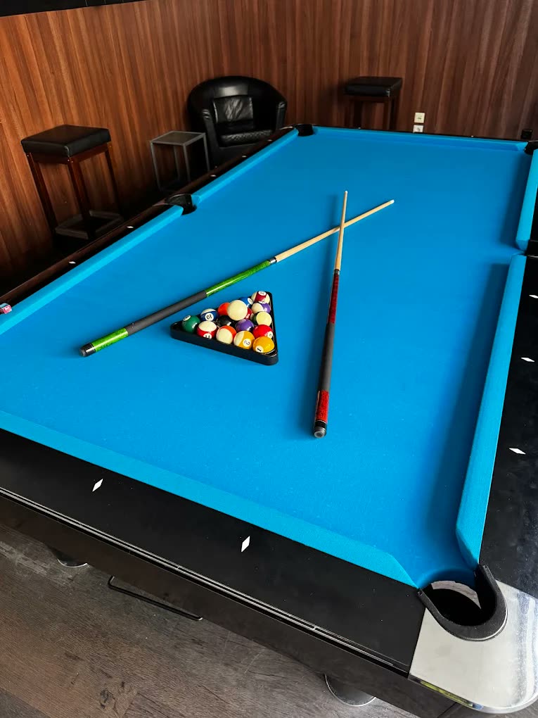Pool-стол с синим сукном, шарами и киями в Billard O.